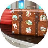 A well-travelled suitcase with stickers from many countries on an airport conveyer belt
